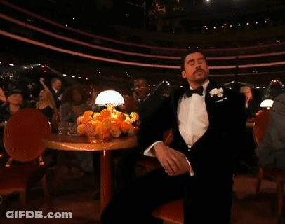 Man In Tuxedo With Hand On Face GIF