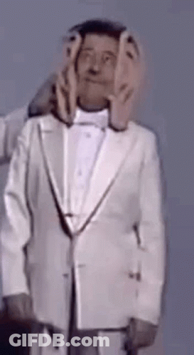 Man In Tuxedo With Hands On Face GIF