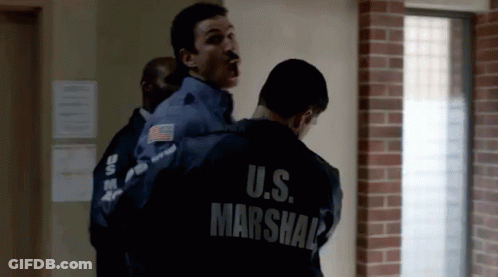 Man In U.S. Marshal Jacket Being Escorted GIF