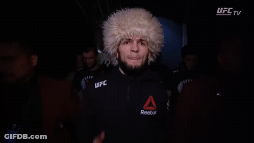 Man In UFC Glove Covers Face In Dark GIF