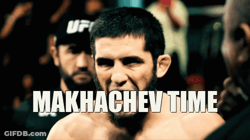 Man In UFC Hat Standing In Front Of Makhachev Time Sign GIF