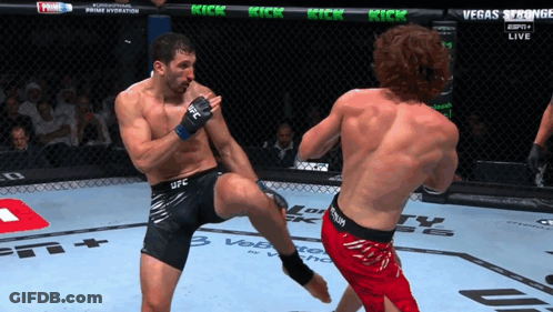 Man In UFC Shorts Kicking Another Man In Cage GIF