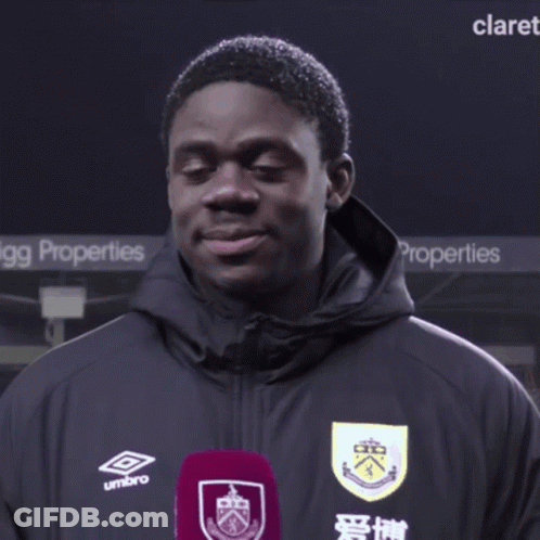 Man In Umbro Jacket Standing In Front Of Properties Sign GIF