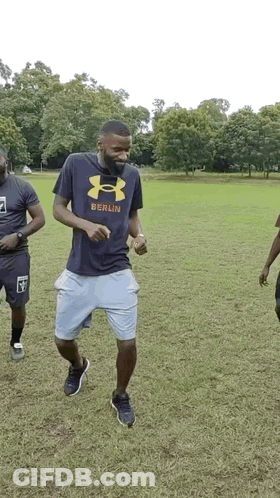Man In Under Armour Shirt Dancing In Field GIF
