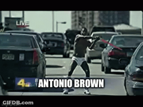 Man In Underwear Holding Red Sword On Busy Street GIF