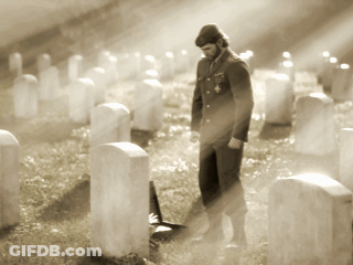 Man In Uniform Among Graves In Cemetery GIF
