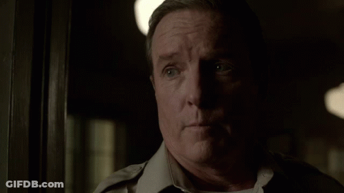 Man In Uniform Standing In Dark Room GIF