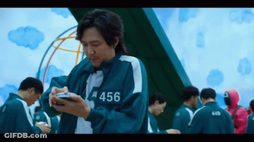 Man In Uniform With 456 Looking At Phone GIF