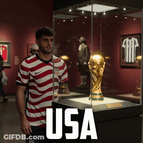 Man In USA Jersey In Front Of Trophy GIF
