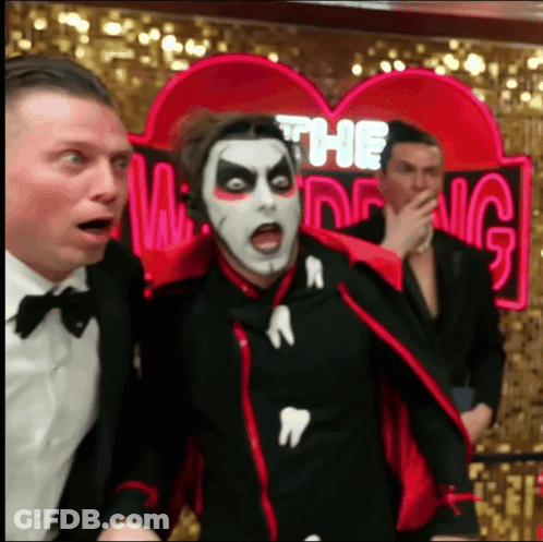 Man In Vampire Costume In Front Of Ring Sign GIF