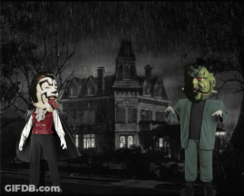 Man In Vampire Costume Next To Man In Green Suit GIF