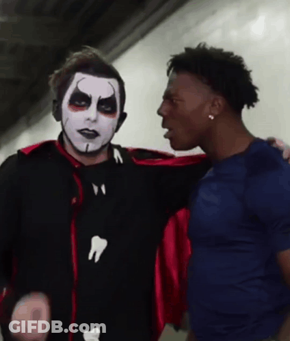Man In Vampire Costume Talking To Man In Blue Shirt GIF
