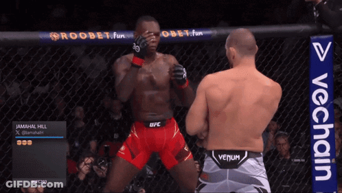 Man In Venum Shorts Next To Man In Red Shorts GIF