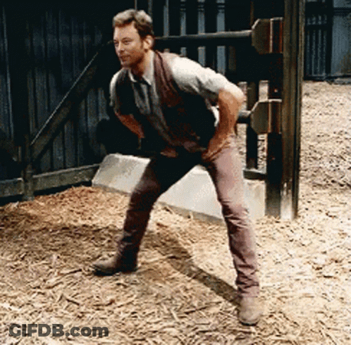 Man In Vest And Brown Pants Standing On One Leg GIF