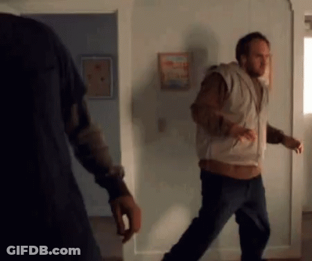 Man In Vest Walking Through Doorway GIF