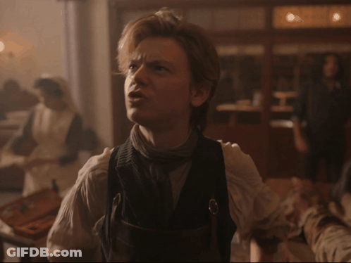 Man In Vest With Woman In White Dress Behind Him GIF