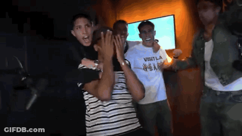 Man In Visitla Shirt Held By Another Man GIF