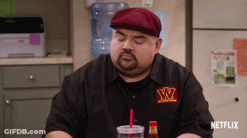Man In W Shirt Sitting In Front Of Netflix Sign GIF
