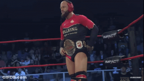 Man In Walking Weapons Shirt Holding Wrestling Belt GIF
