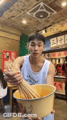 Man In Washington Tank Top Holding Bowl Of Sticks GIF