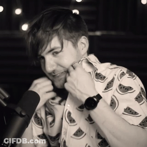Man In Watermelon Shirt Adjusting Collar At Microphone GIF