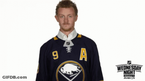 Man In Wednesday Night Live Jersey Holding Hockey Puck GIF