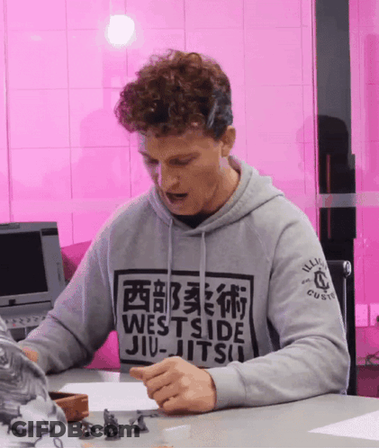 Man In Westside Jiu-Jitsu Hoodie Sitting At Table GIF