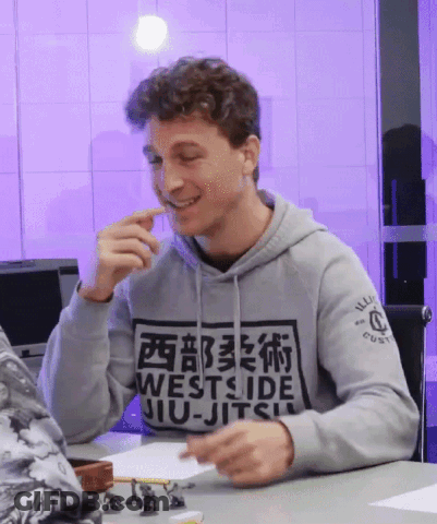 Man In Westside Jiu-Jitsu Hoodie Smiling At Table GIF