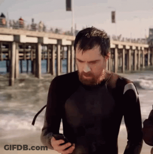 Man In Wetsuit Looking At Cell Phone GIF