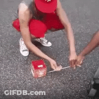 Man In Wheelchair Pushed By Woman In Red Hat GIF