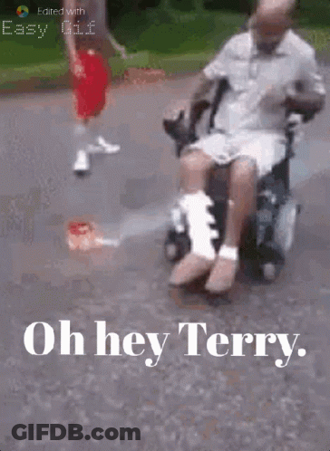 Man In Wheelchair With Leg Bandage Pushed By Another GIF