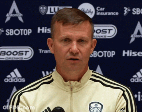 Man In White Adidas Jacket In Front Of Sbotop Banner GIF