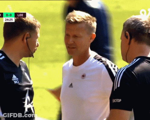 Man In White Adidas Shirt Talks To Two Men GIF