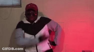 Man In White And Black Jacket Dancing In Red Lights GIF