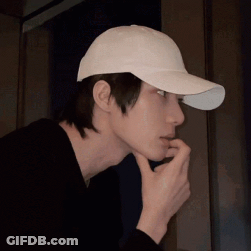 Man In White Baseball Cap Holding Hand To Face GIF
