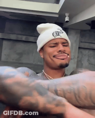 Man In White Beanie Smoking Cigarette Making Face GIF