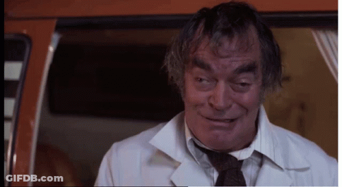 Man In White Coat And Tie Looking At Camera GIF