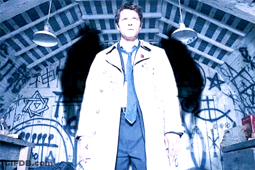 Man In White Coat And Tie Standing In Front Of Graffiti Wall GIF
