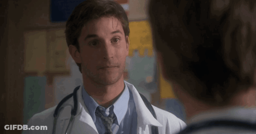 Man In White Coat And Tie Talking To Another Man GIF