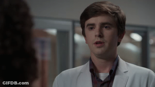 Man In White Coat Looks At Woman In Plaid Shirt GIF