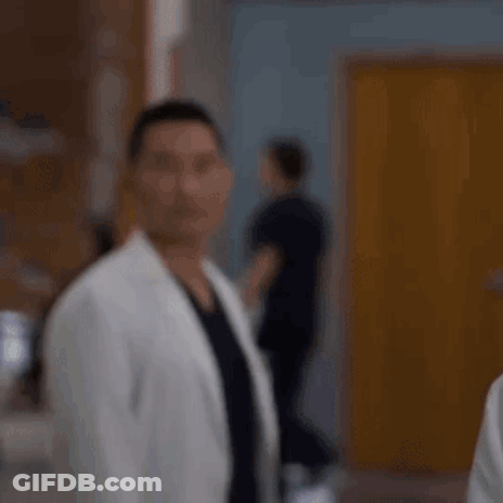 Man In White Coat Standing In Hospital Hallway GIF
