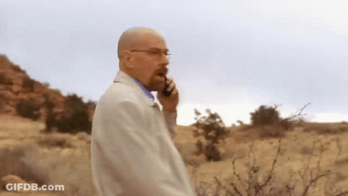 Man In White Coat Talking On Cell Phone In Desert GIF