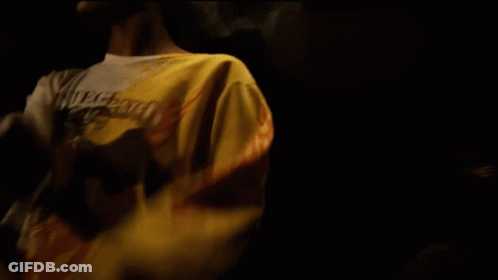 Man In White Coca Cola Shirt In Dark Room GIF