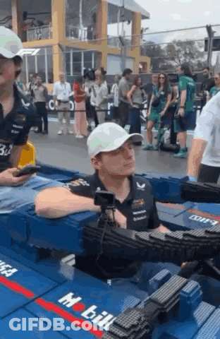 Man In White Hat Sitting In Container With Camera GIF
