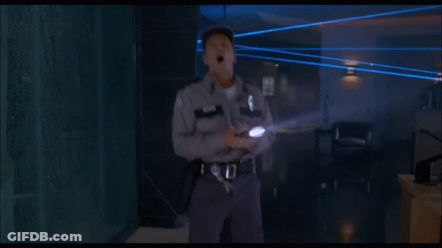 Man In White Hat Walking In Dark Room With Blue Lights GIF