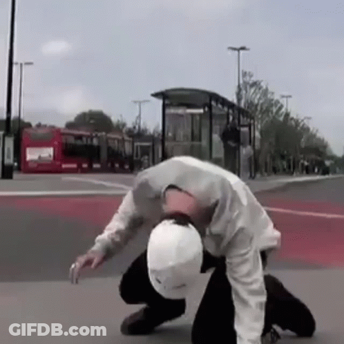 Man In White Helmet Kneeling On Street GIF