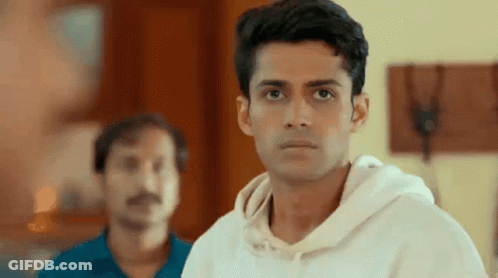 Man In White Hoodie Looks At Camera With Another Man GIF
