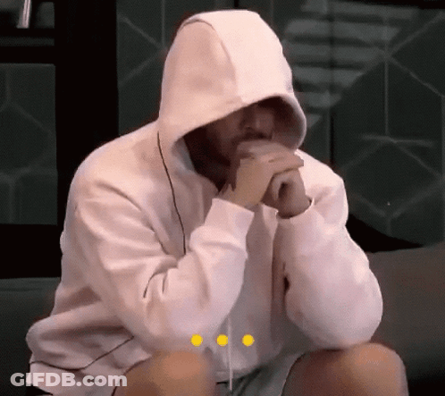 Man In White Hoodie Sitting On Couch With Hands Folded GIF