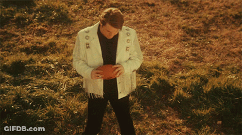 Man In White Jacket Holding Football With Number 1 GIF