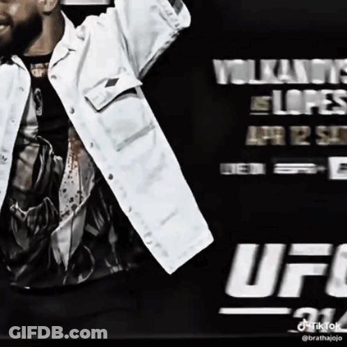 Man In White Jacket In Front Of UFC Sign GIF